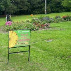House with a well-kept lawn and sign Yard of the month